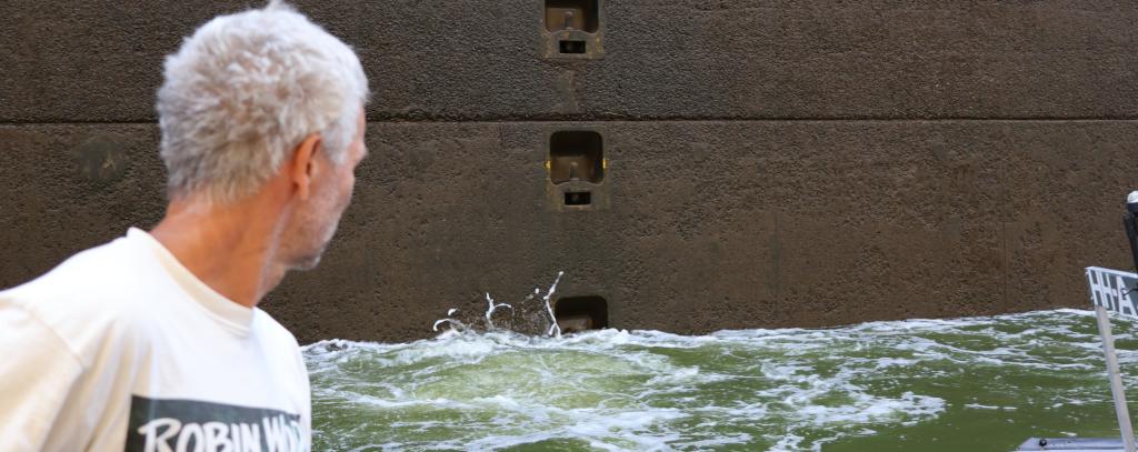 Person auf dem Floß vor Schleusenwand