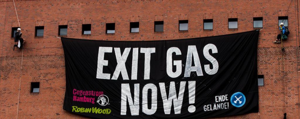 Kletter*innen vor der Fassade der Elbphilharmonie mit einem Protestbanner. Aufschrift: Exit Gas Now!