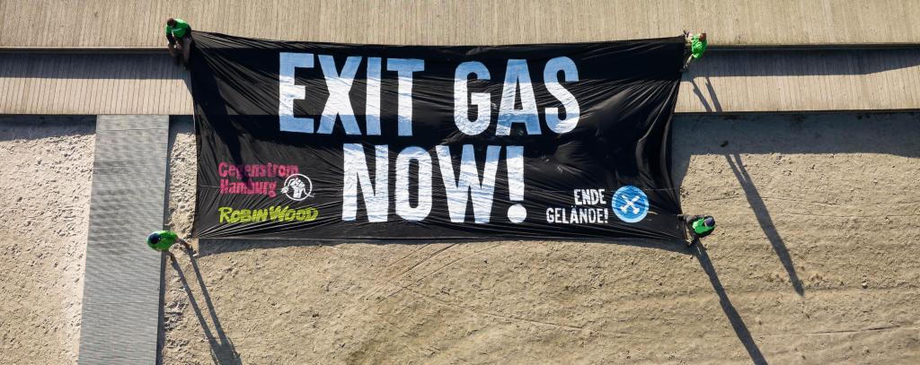 Banner mit Aufschrift "Exit Gas Now" auf dem Boden liegend