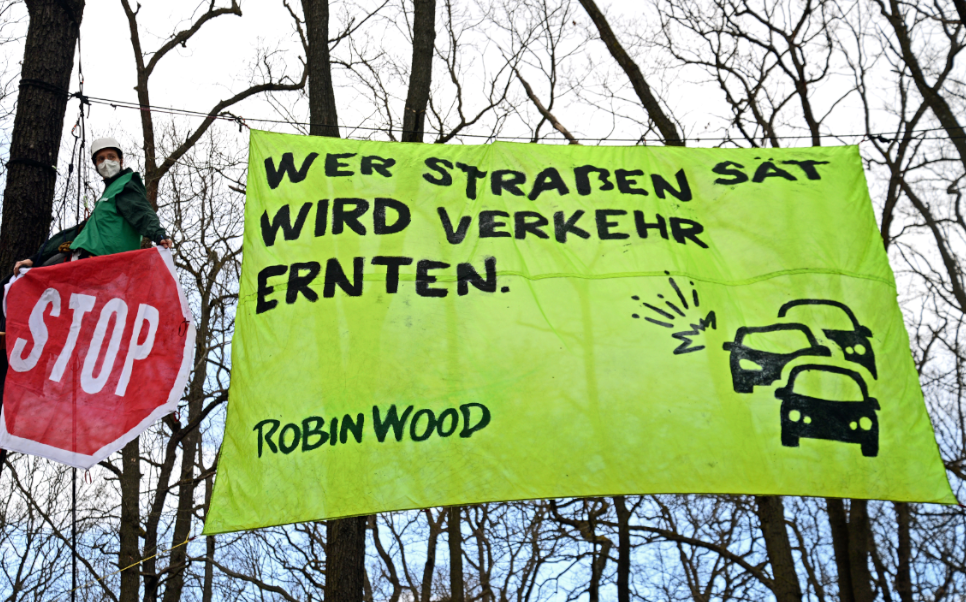 Aktionsfoto mit Banner "Wer Straßen sät, wird Verkehr ernten"
